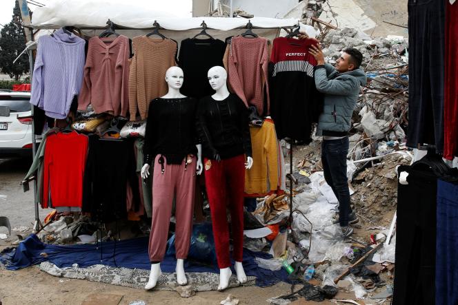 Un stand de vente de vêtements est installé devant les décombres d’un magasin détruit par les frappes aériennes israéliennes en mai, à Gaza, le 20 novembre 2021.